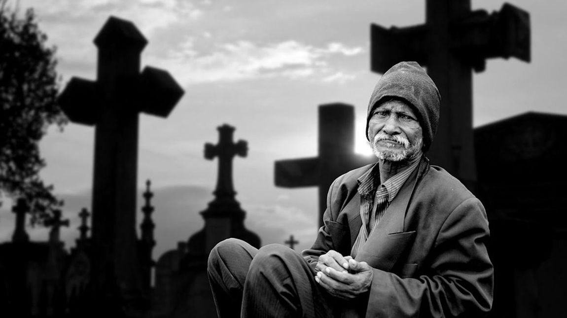 Einsamer Mann am Friedhof